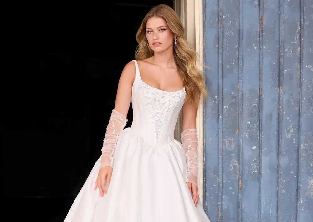 Model wearing a white gown by Sophia Tolli