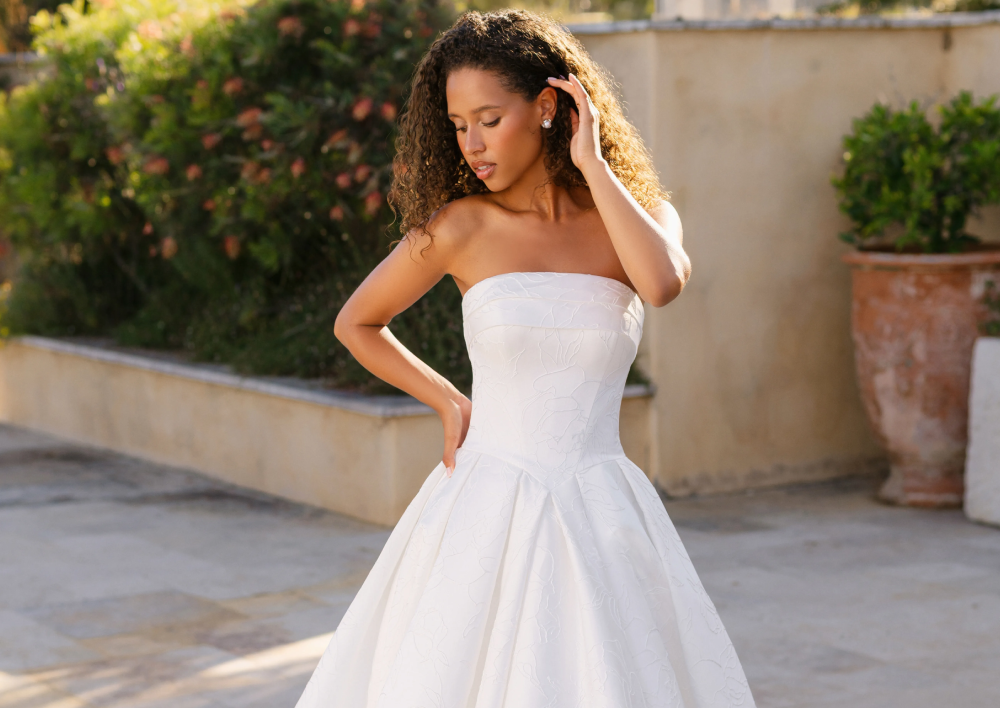 Model wearing a white gown by Allure