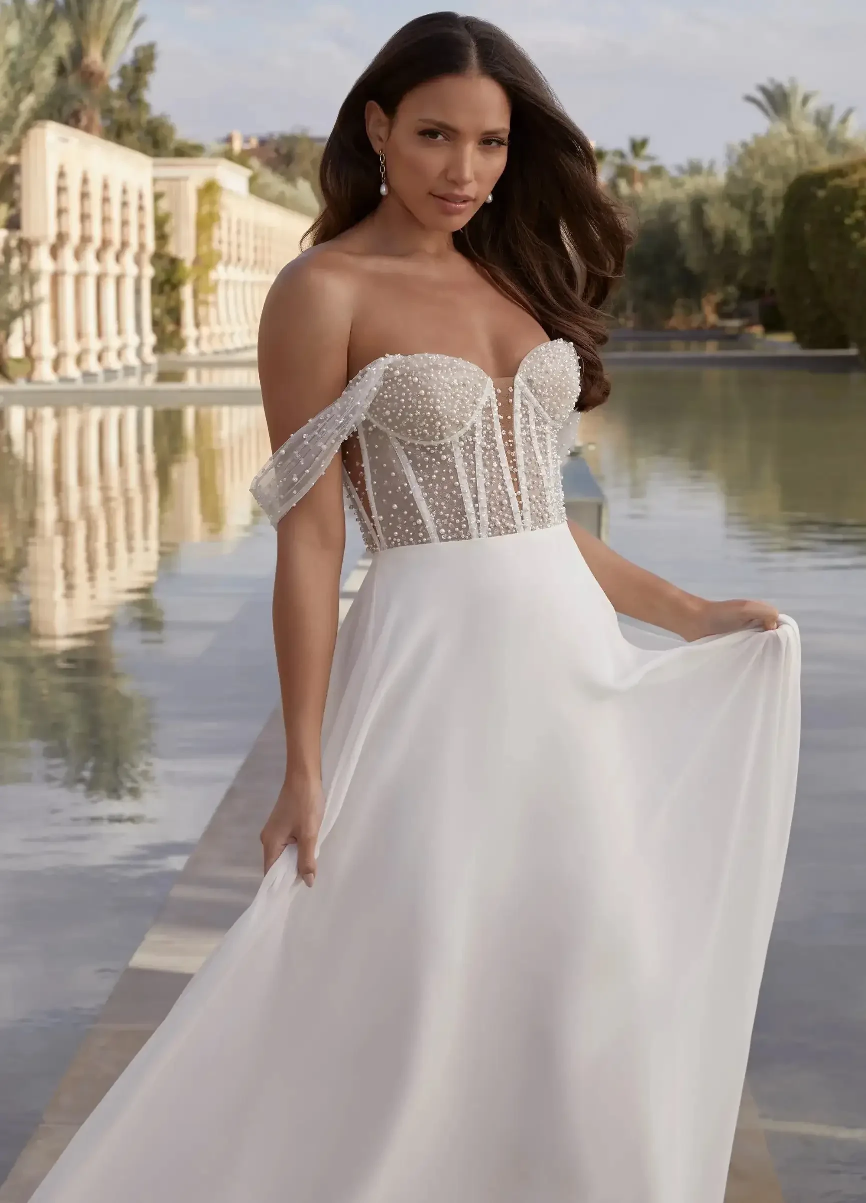 Brunette woman wearing a v-neck flower wedding gown with detachable long tulle cape sleeves