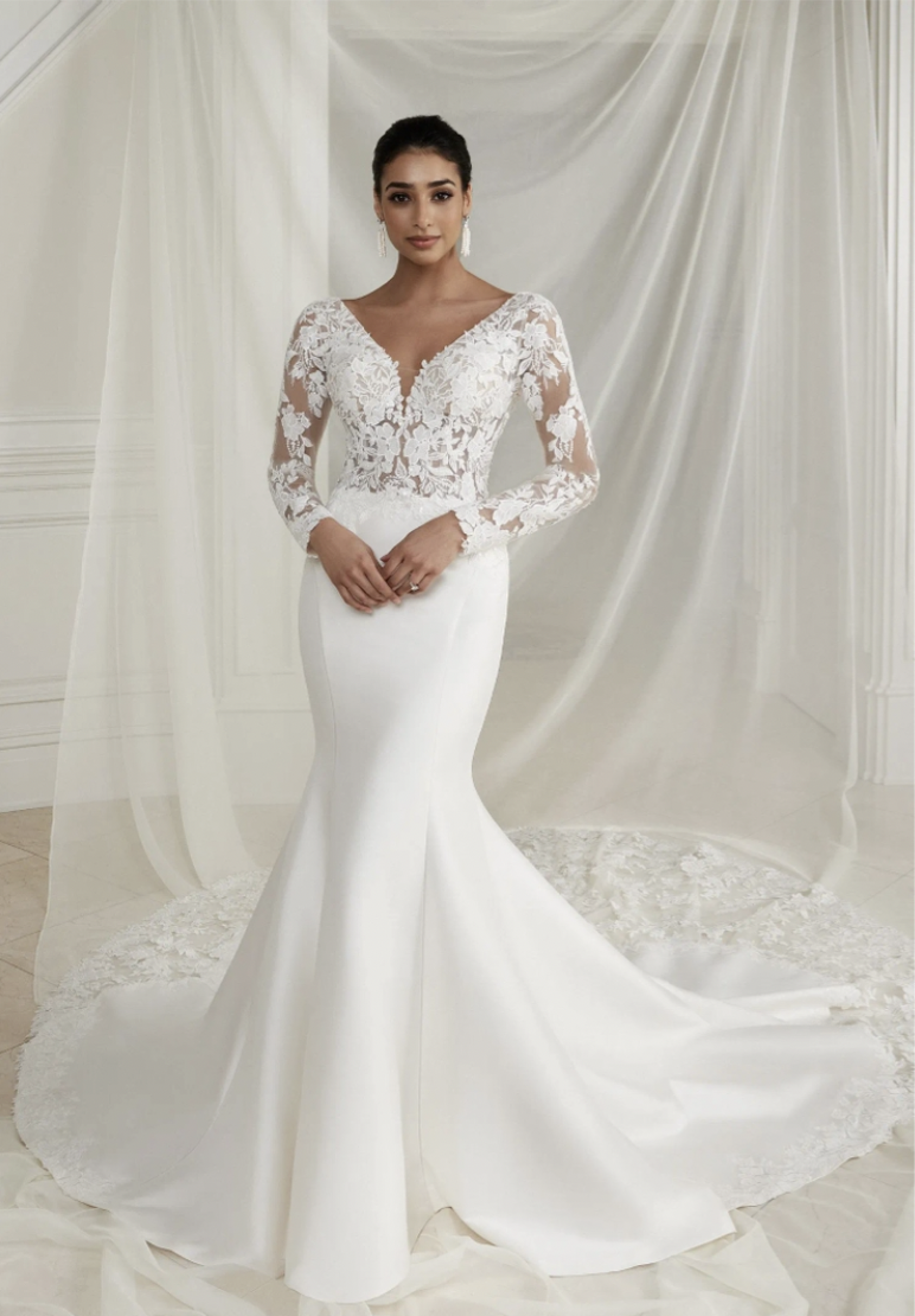 Brunette woman wearing a long sleeve stretch mikado fit and flare with cutout lace train wedding