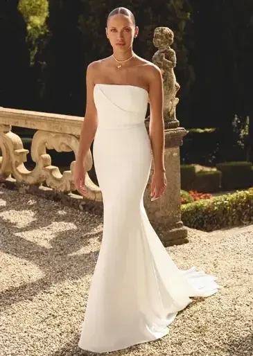 Brunette woman wearing a long sleeve stretch mikado fit and flare with cutout lace train wedding