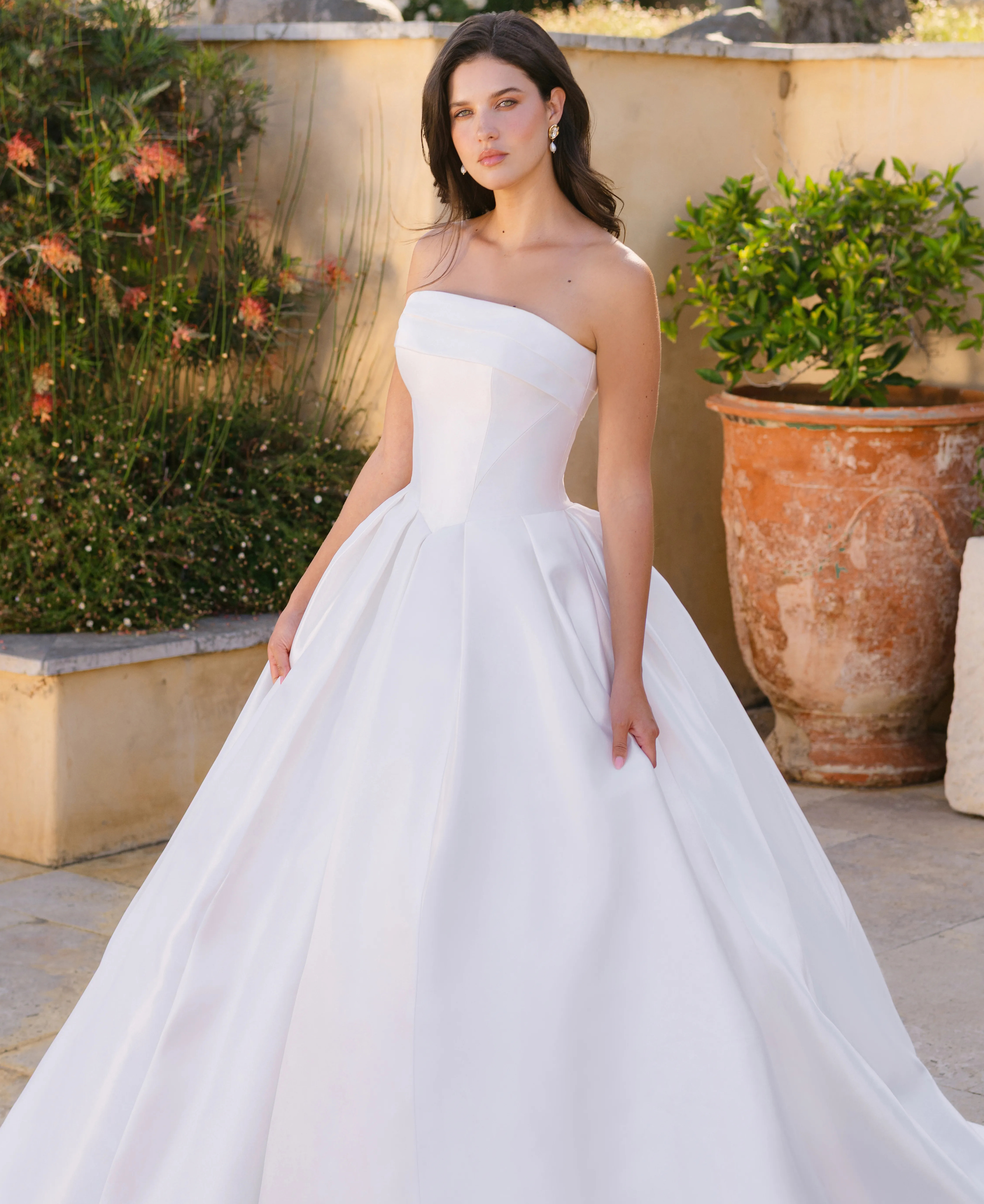 Brunette woman wearing a ballgown wedding dress featuring a straight neckline